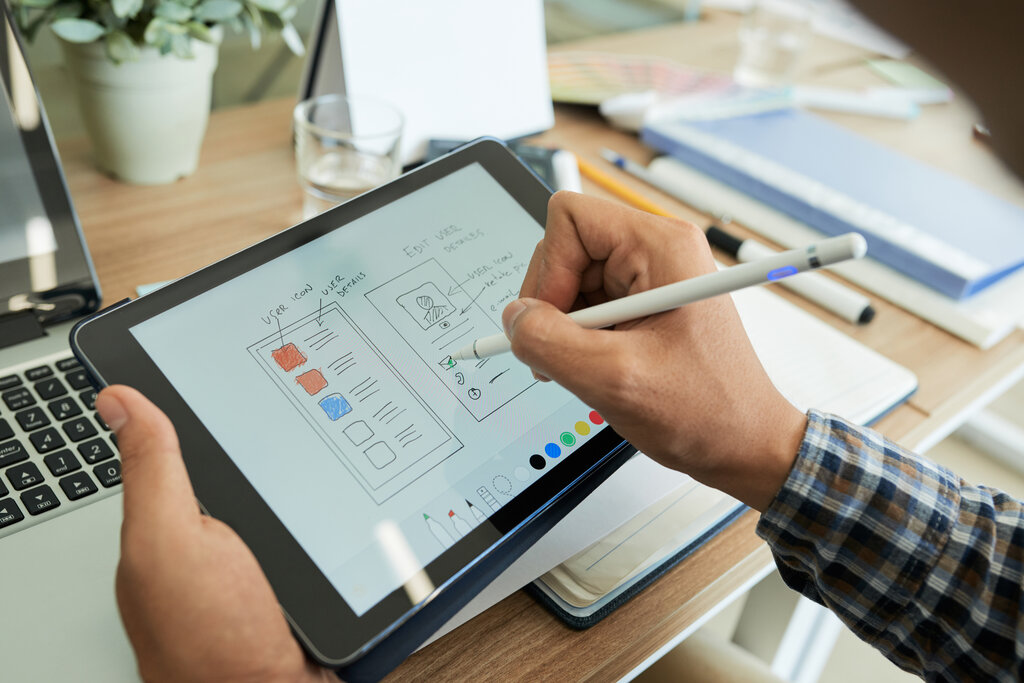 man designing mobile app on tablet device